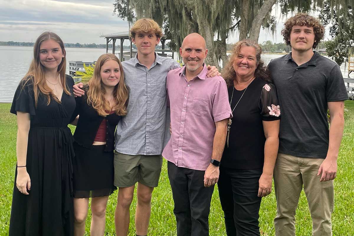 two parents and four children pose outside for a family photo